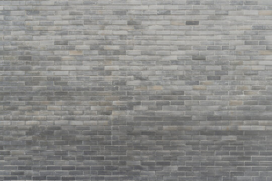 Black, dark grey brick wall texture background of mansory stone tile block pattern painted in gray color wallpaper modern interior and exterior and backdrop design