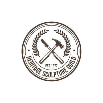 Heritage Sculpture Guild circular logo featuring a crossed hammer and chisel within a laurel wreath.
