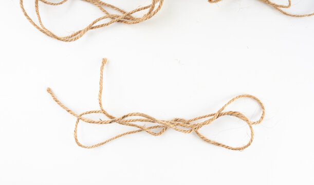 Twine rope piece isolated, jute loop fragment, beige packaging cord knots, old natural line cable