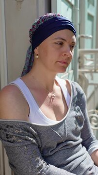 Thoughtful woman wearing patterned headscarf looking into distance outdoors capturing emotional resilience personal reflection and authentic lifestyle portrait in natural sunlight