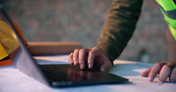 Architect, typing and hands with laptop on construction site, info and plan for property development. Civil engineering, research and person with tech, scroll and architecture design with blueprint