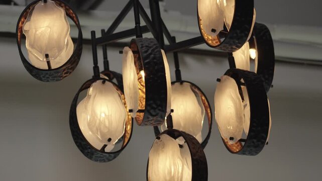 A close-up view of a contemporary light fixture featuring circular, textured shades. Ideal for interior design showcases or architectural presentations.