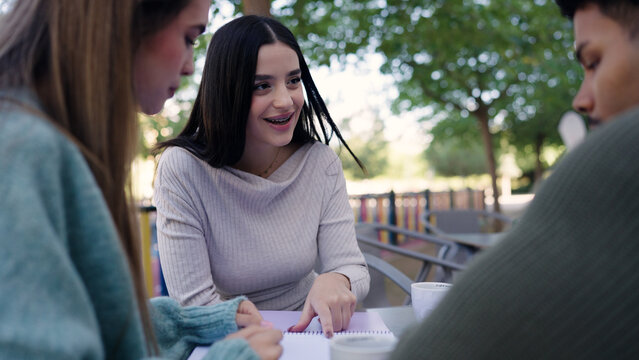Students learning and studying together on university campus, working on a project and discussing ideas as friends