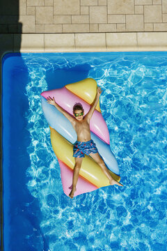 Child in swimming pool. Having fun on vacation at the hotel pool. Colorful vacation concept.