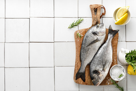 Fresh raw dorado fish cooking with ingredients. Sea bream, dorado. Seafood, healthy food. Top view