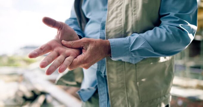 Construction, pain and hands of man with massage for injury, accident and carpal tunnel at site. Engineering, contractor and person with strain for tendinitis, fibromyalgia and wrist sprain outdoor
