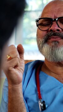 Indian male doctor consulting male patient during routine medical discussion as experienced physician advises young man inside modern Indian clinic OPD healthcare consultation