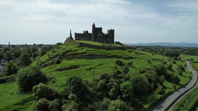Aerial drone footage of the Rock of Cashel, a historic medieval fortress and cathedral complex in County Tipperary, Ireland, on a sunny day