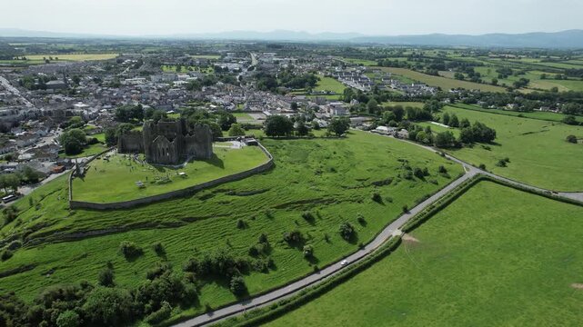 Aerial drone footage of the Rock of Cashel, a historic medieval fortress and cathedral complex in County Tipperary, Ireland, on a sunny day