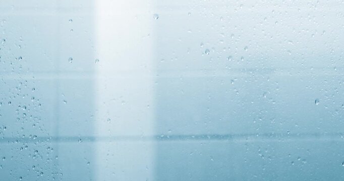 Water droplets on shower glass creating a soft wet texture. Water Texture, Cleanliness, hygiene, freshness, relaxation, moisture, and modern bathroom interior background