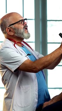 Indian male doctor checking male patient with torch during routine medical examination as experienced physician assesses young man inside modern Indian clinic OPD healthcare visit