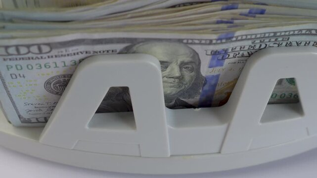 Money counting machine processing 100 Dollar bills, close up jib studio shot, slow motion