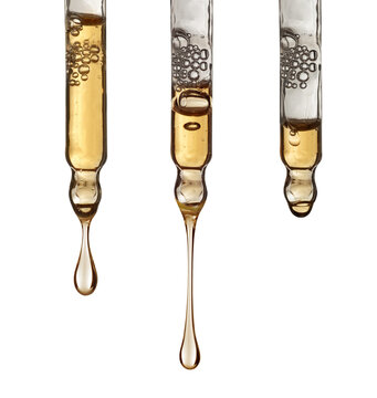 Glass pipettes with drops of cosmetic serum and air bubbles