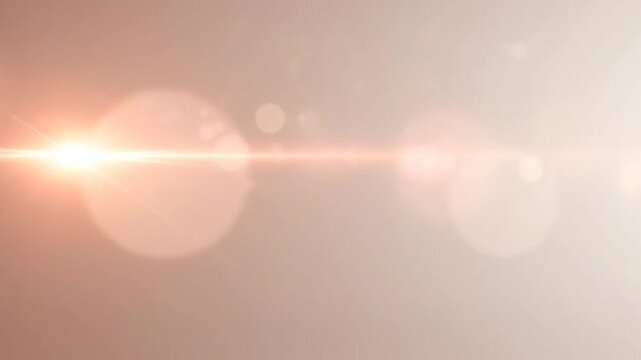 Soft abstract peach background with lens flare and bokeh.