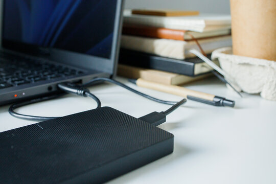 Using external hard drive disk through usb cable connection to laptop. Saving data on different sources, safe data security, computer memory unloading, modern technology, using devices at the office