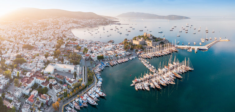 Bodrum city showing Castle of St. Peter and marina filled with many yachts on Aegean Sea during golden hour