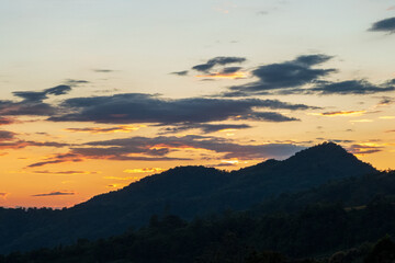 Obraz premium Blue golden sky sunrise dramatic beautiful landscape mountain. Dramatic sunset over mountain landscape. Beautiful landscape foggy hills twilight time. Dawn sky gold dusk time cloudscape with sunlight