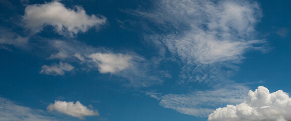 Fototapeta premium Banner Blue sky fluffy white clouds on summer season bright clear skyline with beautiful cloudscape. Banner Heaven blue high scenic nature. Tropical summer blue sky fluffy white cloud with copy space