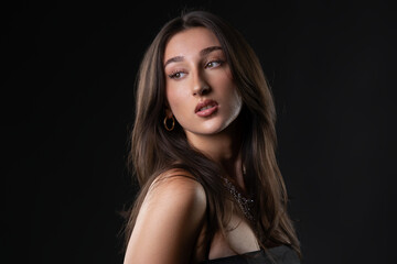 Fototapeta premium Young woman looking away, showcasing beauty and fashion style in a studio portrait