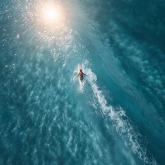 Obraz premium A surfer rides a wave in the ocean. A surfer lying on a white surfboard rides a small wave on turquoise water, sun rays, aerial view from above. Summer surfing.