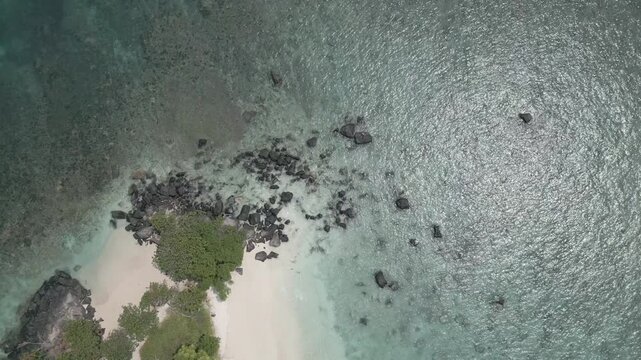 Top Down Aerial Of Volcanic Boulders White Sand And Clear Shallows