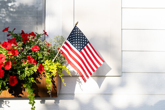 Small American Flag in Flower Window Box with Red Petunias on White House