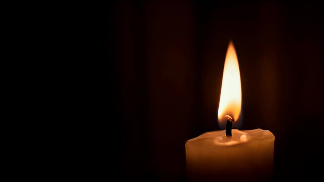 Single lit white candle flame burning brightly in dark background with melted wax dripping down side of pillar taper