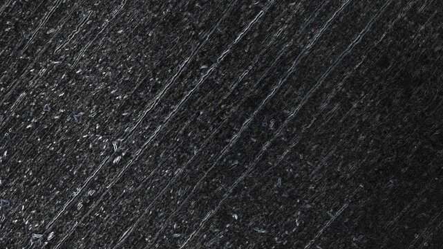 Dark scratched surface with diagonal grooves, reflective specks, and rugged metallic-like texture throughout. Grunge texture background animation.