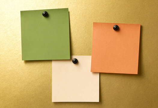 Three Colorful Sticky Notes Pinned to a Textured Surface