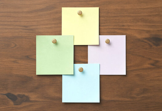 Four Colorful Sticky Notes Pinned to a Wooden Surface, Flat Lay Composition