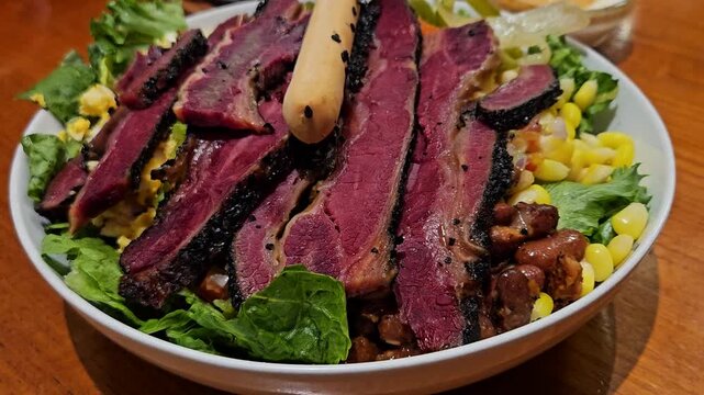 This is a salad with beef in the bowl