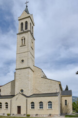 Fototapeta premium Historic limestone facade of Church of the Assumption of the Blessed Virgin Mary during a peaceful day