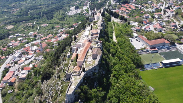 Aerial views of the entire Klis Fortress on a rocky cliff with a slight rotation Croatia