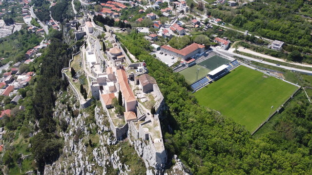 Aerial views of the entire Klis Fortress on a rocky cliff with a slight rotation Croatia
