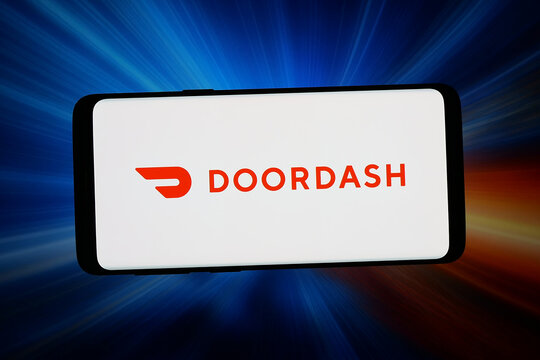 Stuttgart, Germany - 06-11-2026: In this photo illustration, the logo of US food delivery company DoorDash Inc. is displayed on a smartphone in front of abstract background on computer screen.