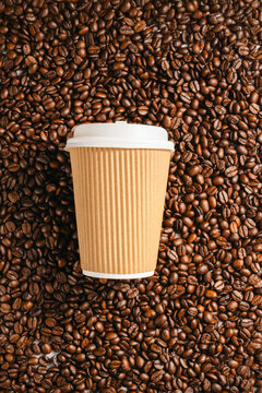 Takeaway coffee cup mockup on roasted coffee beans background, top view template for branding