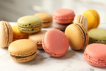 Fototapeta premium Different tasty macarons on white marble table indoors, closeup