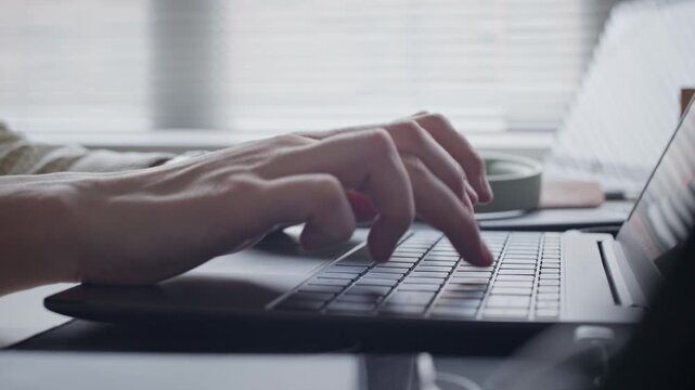 Close up on hands of Caucasian young adult developer typing on laptop keyboard, coding software in office. Clip for marketing campaigns about software engineering, IT services, and AI technology