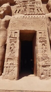 Ancient egyptian hieroglyphs and statues adorning the facade of the small temple of nefertari in abu simbel, a historical site in nubia