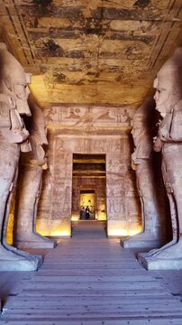 Ancient hieroglyphs and colossal statues of ramses ii lining the grand hall of the abu simbel temple, a nubian monument in egypt
