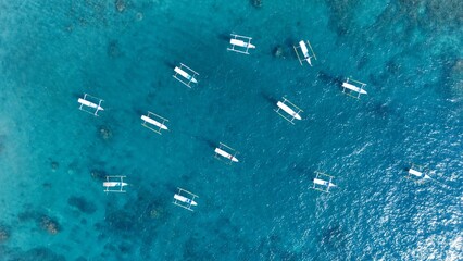Aerial overhead view of many traditional boats anchored in turquoise ocean Nusa Penida Bali © 7 Fine Art