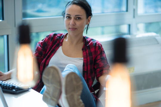 Confident Creative Professional Sitting with Feet on Desk in Office