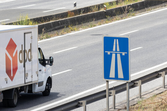 Dpd delivery van driving on highway near autobahn sign