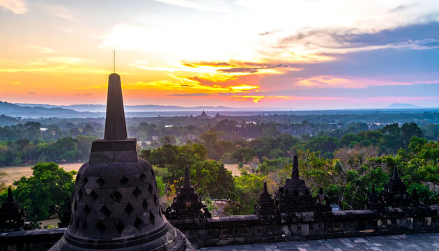 Sunrise over Borobudur temple in Java, Indonesia, featuring ancient stupas and lush green forest landscape