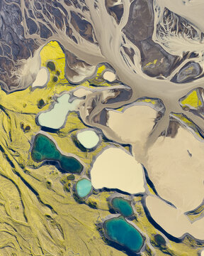 Aerial view of the abstract patterns of a glacial river delta with colorful sediment pools and braided channels near Myrdalsjokull in Vik, Myrdalshreppur, Iceland.