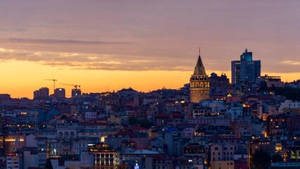 Obraz premium Istanbul, Turkey - June 13, 2026: Scenic evening view of Galata Tower with sunset sky in the background, featuring the historic landmark, warm light, city rooftops, and the atmospheric skyline