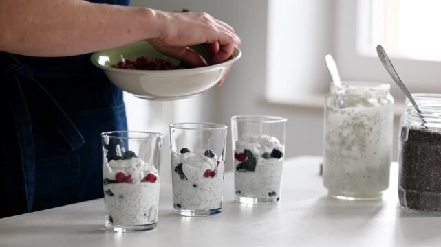 Female Hands Add Fresh Red And Black Berries To Homemade Yogurt With Chia Seeds