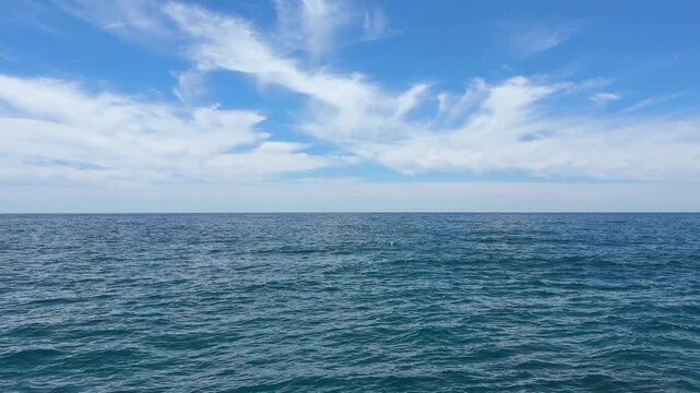 Blue sea waves and sky with beautiful clouds.