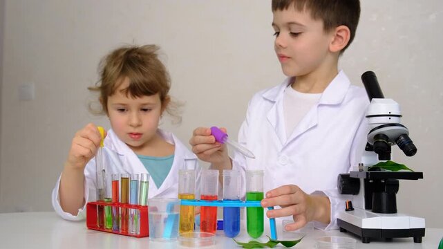 Laboratory examination of a child with test tubes, reagents and a microscope. Selective focus.