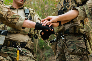 Fototapeta premium Special forces units, armed with war weapons are joining forces in unity surprise attack preparing mission to assault the enemy military. 